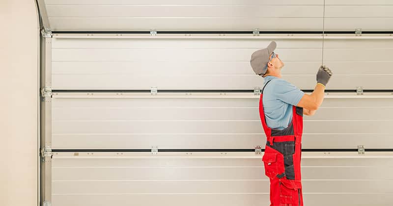 Man installing a garage door inside